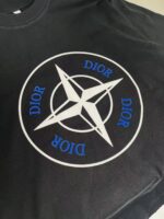 T-shirt nero Dior con logo geometrico e stella bianca, stile moderno e di alta moda.