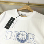 Maglietta Dior bianca con logo blu e dettagli eleganti, stile raffinato e di lusso.