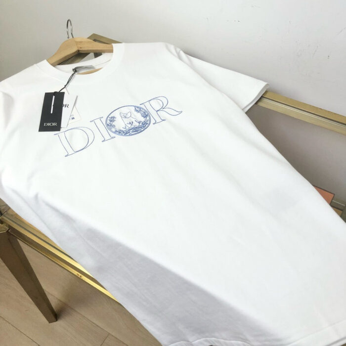 Maglietta bianca Dior con logo circolare e design moderno, tessuto morbido e stile elegante.