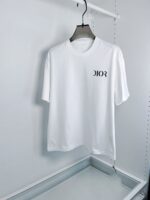 Maglietta bianca Dior con logo elegante, stile minimalista, su appendiabiti moderno.