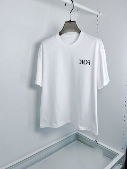 Maglietta bianca Dior con logo elegante, stile minimalista, su appendiabiti moderno.