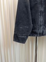 Dettaglio di una giacca in denim vintage con polsino sfilacciato e stile retrò.