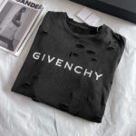 Maglietta Givenchy nera con logo, dettagli destrutturati e stile streetwear elegante.