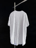 T-shirt oversize bianco con dettagli distressed per uno stile casual e moderno.