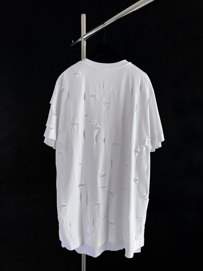 T-shirt oversize bianco con dettagli distressed per uno stile casual e moderno.