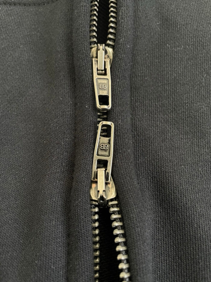 Cerniera a doppio senso in metallo nero su tessuto sportivo, stile e funzionalità moderna.