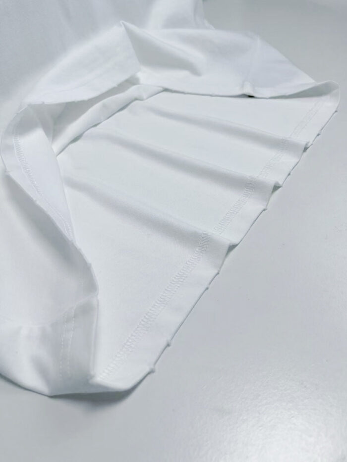 Tela bianca morbida e elegante con pieghe delicatamente drappeggiate su sfondo neutro.