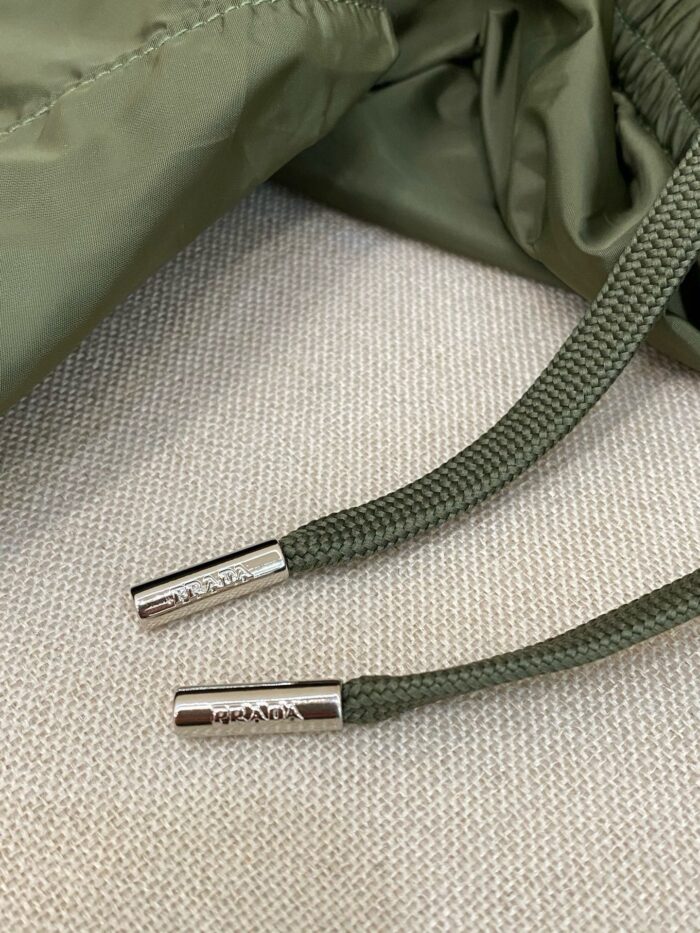 Cordino in oliva con aglet in metallo su giacca sportiva leggera.