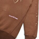 Felpa marrone con stelle dorate e scritta rosa, stile urbano e casual.
