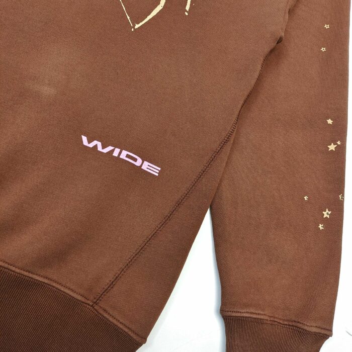 Felpa marrone con stelle dorate e scritta rosa, stile urbano e casual.