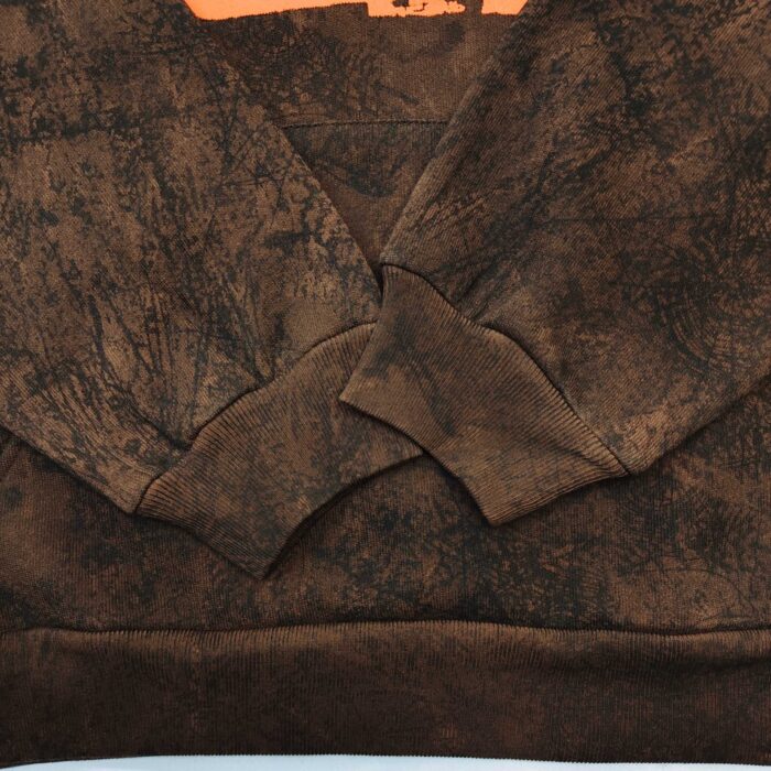 Felpa marrone con dettaglio arancione e texture naturale, stile casual e moderno.