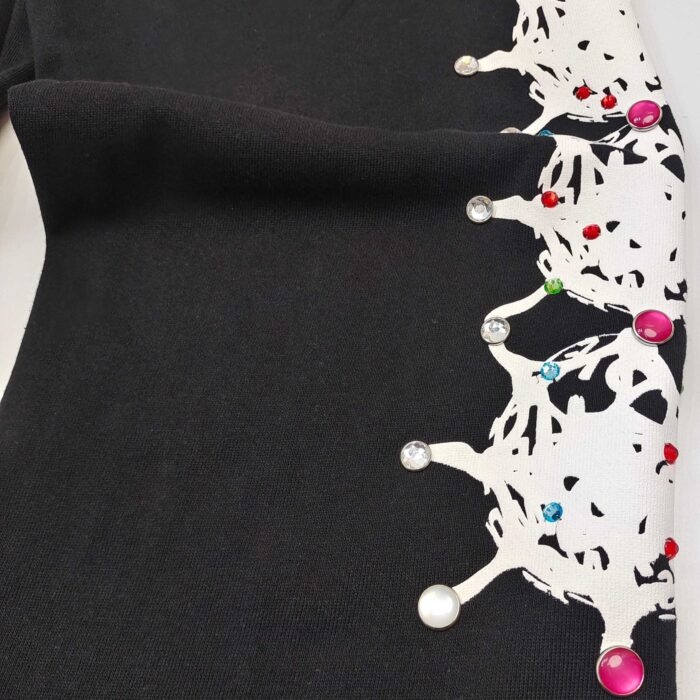 Abito nero con dettagli a corona bianca e perline colorate, elegante e vivace, ideale per occasioni speciali.