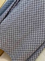 Tessuto geometrico grigio con dettagli eleganti e texture raffinata per arredi e moda.