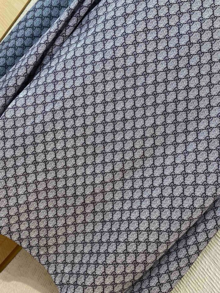 Tessuto geometrico grigio con dettagli eleganti e texture raffinata per arredi e moda.