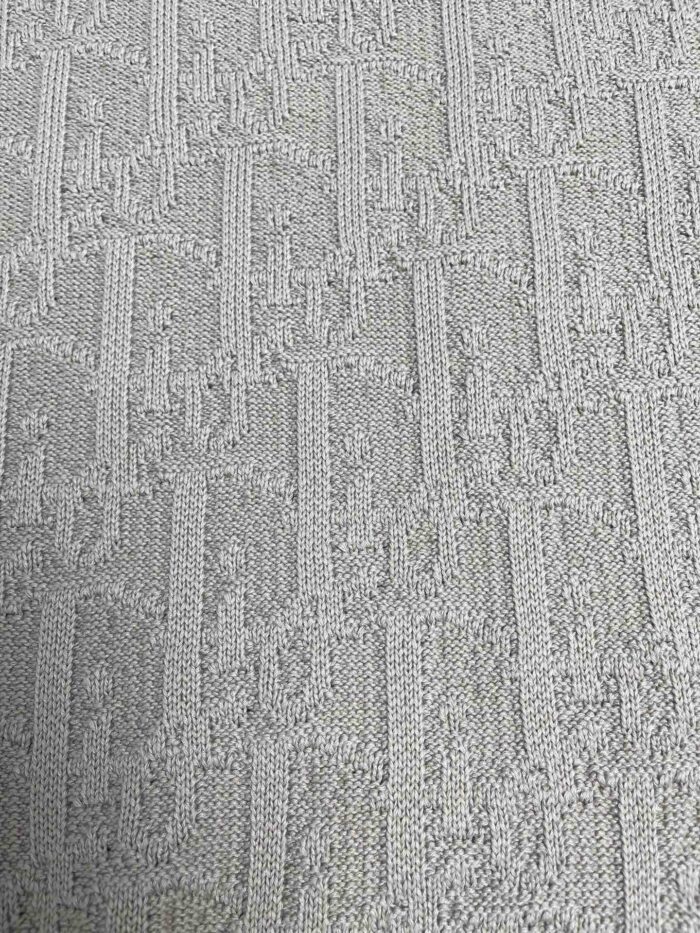 Tessuto neutro con motivo geometrico elegante e texture soffice, perfetto per arredamento sofisticato.