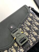 Borsa moderna in pelle verde con dettaglio metallico e motivo monogramma elegante.