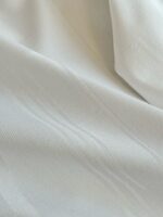 Tessuto leggero e raffinato con sottili righe dorate, ideale per abbigliamento e decorazioni eleganti.