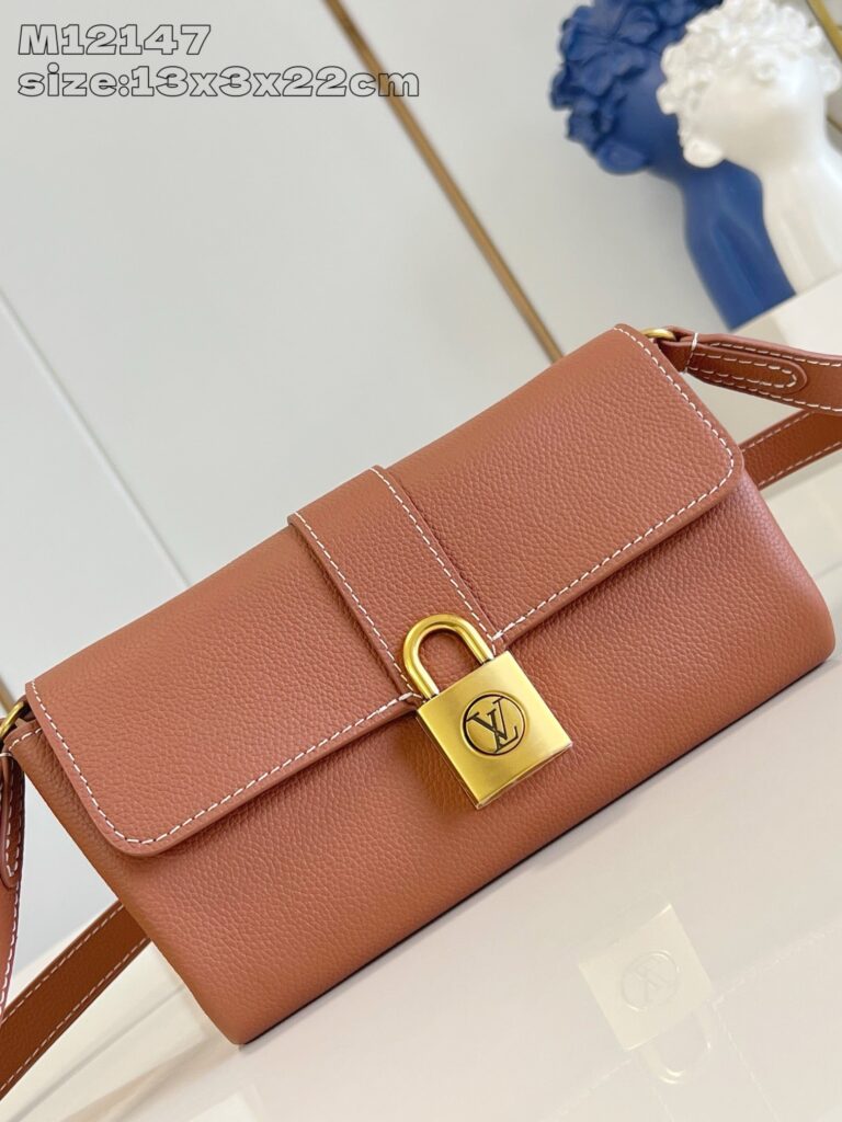 Borsa elegante in pelle marrone con chiusura oro e tracolla regolabile, stile sofisticato e moderno.
