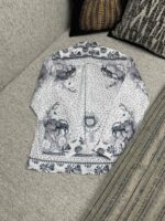Camicia vintage con stampa artistica su divano morbido e decorato con cuscini eleganti.