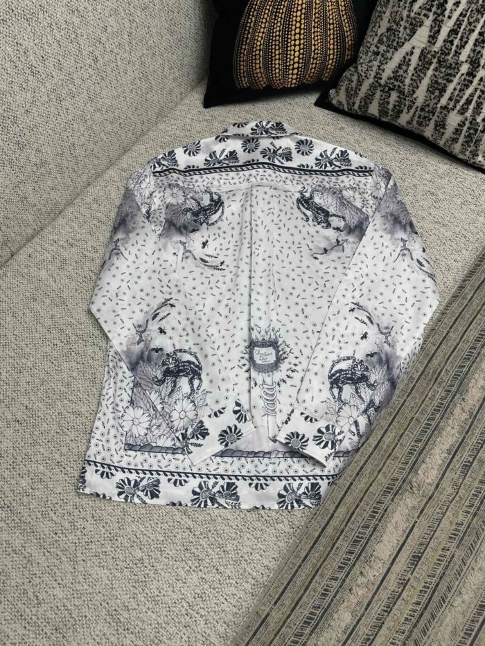 Camicia vintage con stampa artistica su divano morbido e decorato con cuscini eleganti.