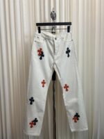 Jeans bianchi decorati con ricami a croce colorati, stile casual e fashion, perfetti per l’estate.
