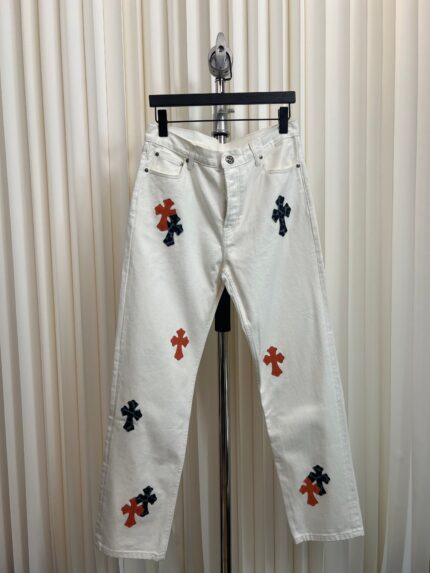 Jeans bianchi decorati con ricami a croce colorati, stile casual e fashion, perfetti per l’estate.
