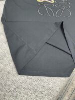 Tessuto nero ricamato con dettagli eleganti e brillantezza, ideale per abbigliamento o decorazioni.