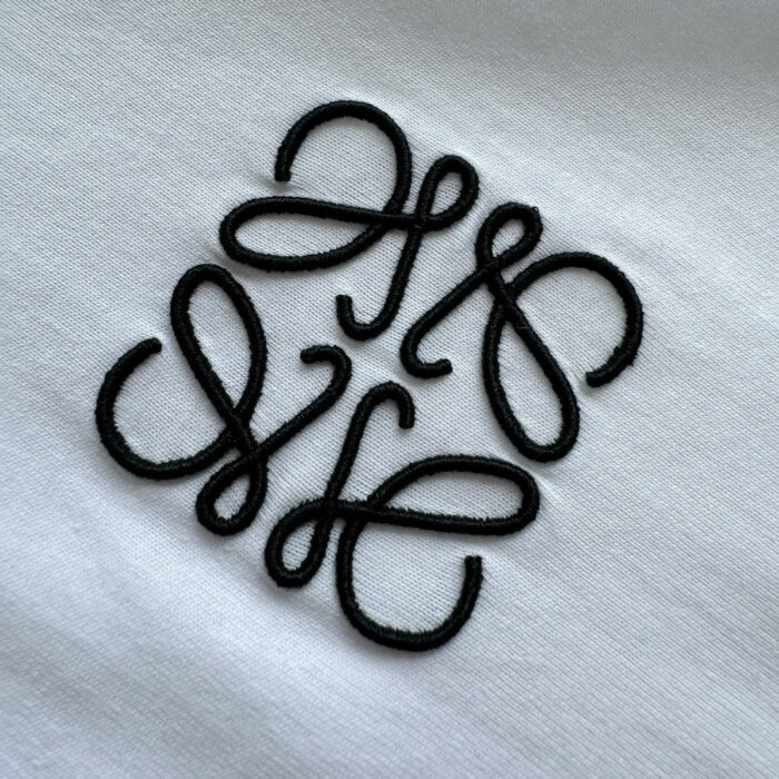 Ricamo nero elegante su maglietta bianca, design astratto sofisticato e moderno.