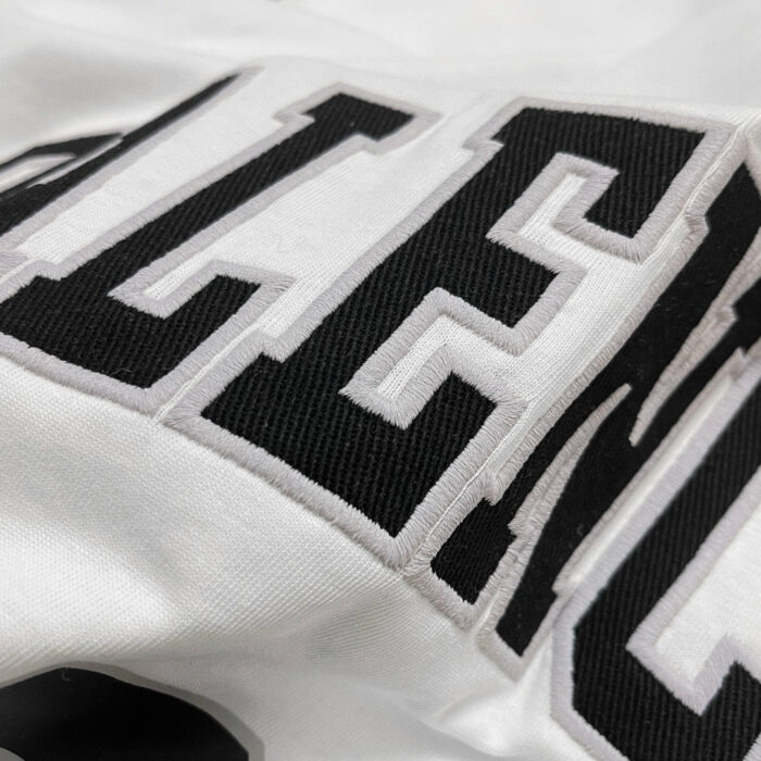 Maglietta streetwear con logo grafico nero e bianco, stile moderno e di alta qualità.