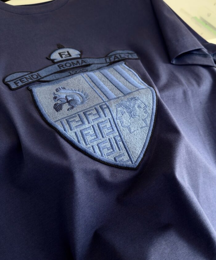 T-shirt navy con ricamo dettagliato felice ROMA, stile elegante e simboli di orgoglio culturale.