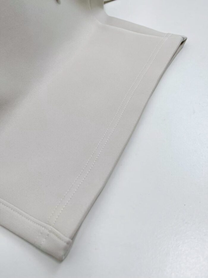 Tessuto beige liscio con orli rifiniti, elegante e versatile per arredamento e abbigliamento.