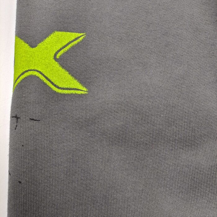 Tessuto grigio morbido con grafico a grande X giallo sportivo e dinamico.