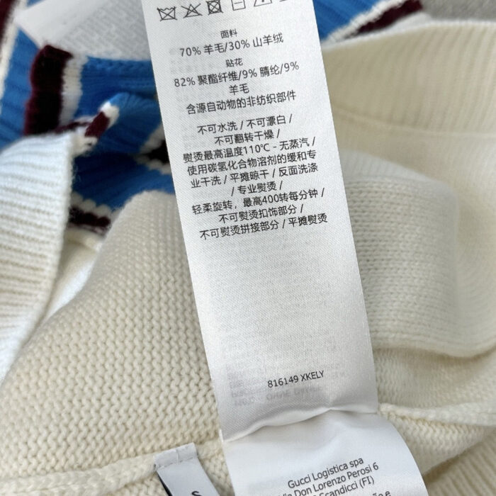Etichetta tessile con istruzioni di cura e composizione materiali del maglione in cotone e lana.