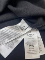 Dettaglio di etichette di cura e marchio su abbigliamento casual o sportivo.