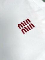 Maglietta bianca con logo rosso astratto e moderno, stile minimalista e contemporaneo.