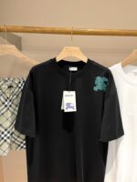 Set di moda estiva: T-shirt nere, bianche e shorts a quadri su sfondo neutro elegante.