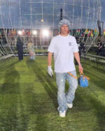 Jeune homme stylé en passerelle futuriste avec sneakers, sac luxury, ambiance vibrante et internationale.