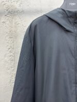 Giacca Fendi moderna grigia con cappuccio, stile minimalista e design elegante.