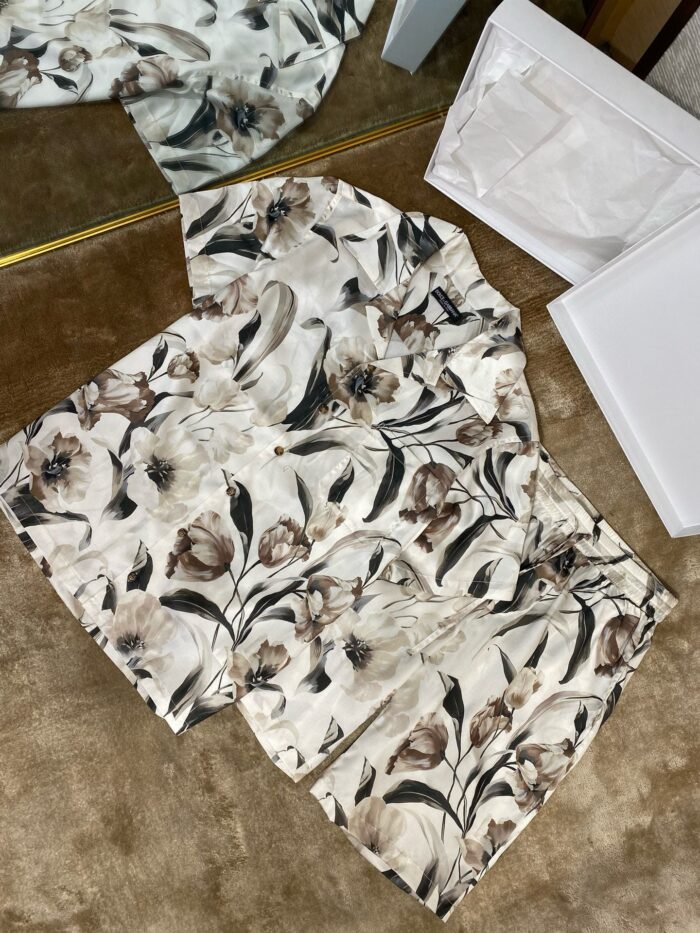 Elegant floral beige shirt unboxing on cozy carpet with packaging and soft lighting.