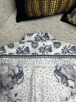 Camicia bianca con design floreali e ispirazioni naturali, vista posteriore elegante e dettagliata.