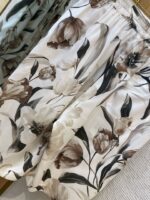 Lightweight floral print loose-fit pants in beige and blush, perfect for casual warm-weather wear.