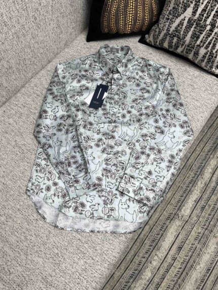 Camicia a fiori a maniche lunghe, nuova, casual, su divano decorato.