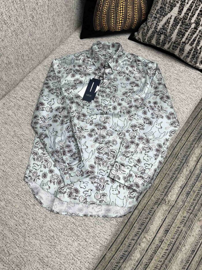 Camicia a fiori a maniche lunghe, nuova, casual, su divano decorato.