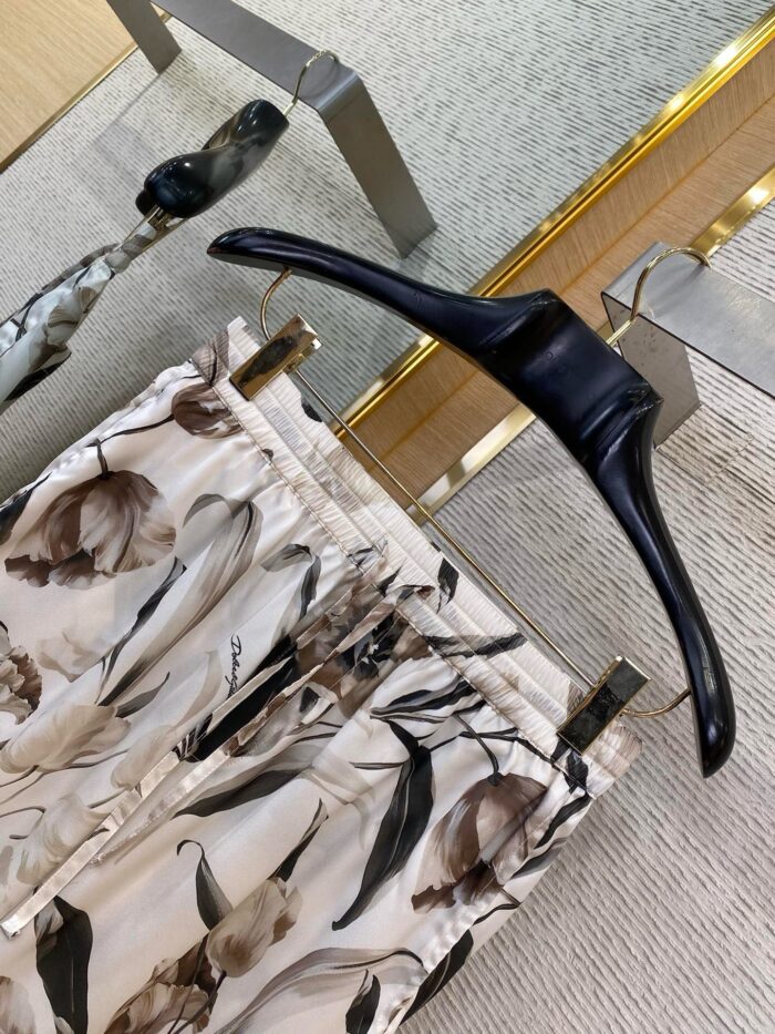 Pantaloni floreali in satin su gancio moderno, eleganti e delicati, ideale per uno stile sofisticato.
