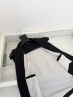 Gilet nero con fodera bianca, elegante e moderno, in esposizione con display in vetro.