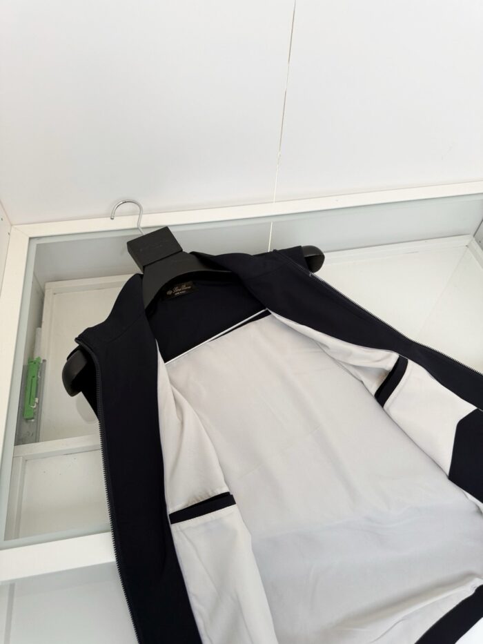 Gilet nero con fodera bianca, elegante e moderno, in esposizione con display in vetro.