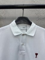 Maglietta polo bianca con logo cuore rosso ricamato, stile casual ed elegante, cotone traspirante.