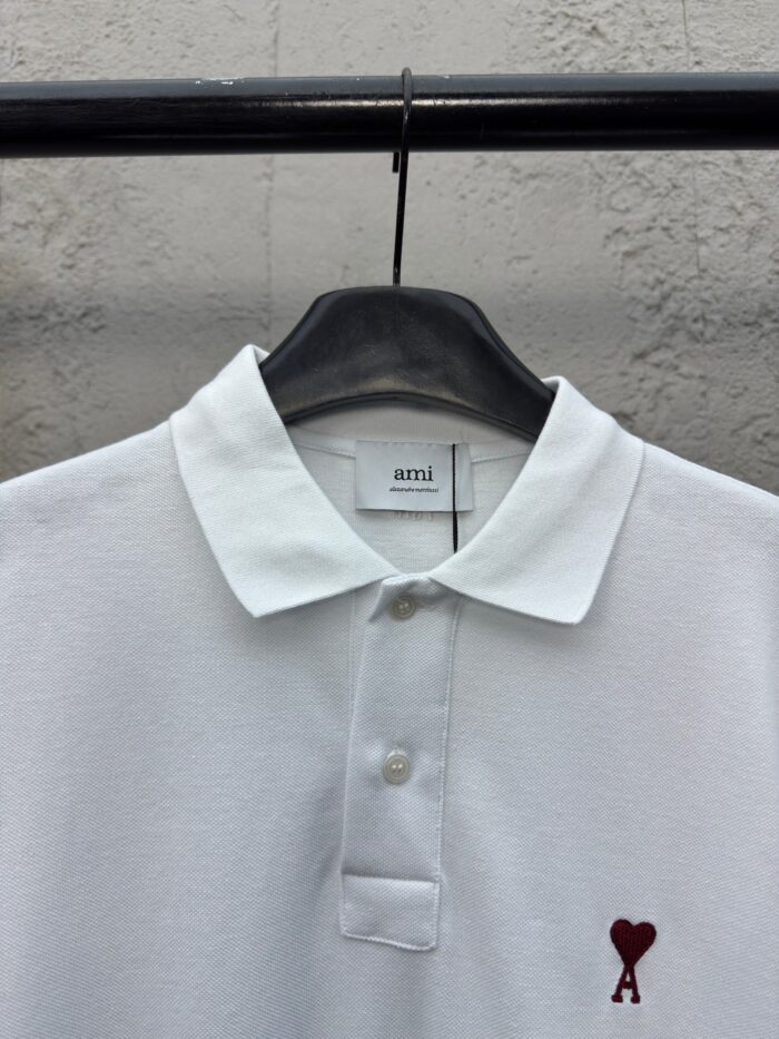 Maglietta polo bianca con logo cuore rosso ricamato, stile casual ed elegante, cotone traspirante.