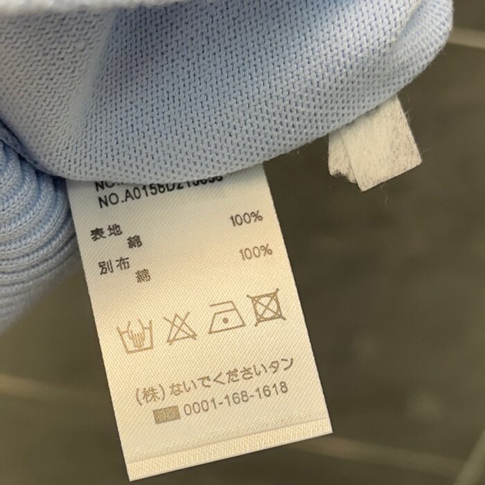Etichetta in cotone con istruzioni di lavaggio e icone per cura del capo.