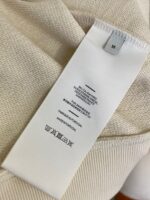 Etichetta vestito con taglia M, istruzioni di cura e dettagli di fabbricazione.